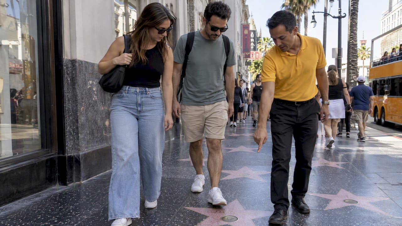Guide pointing out star on Hollywood Walk of Fame