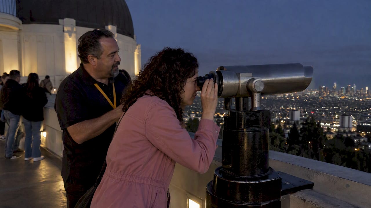 Visitor using a public telescope after sunset
