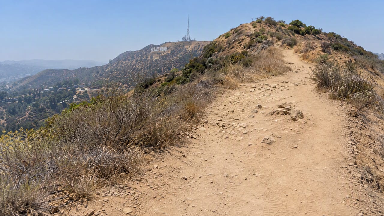 Sun-exposed trail crossing a dry hillside